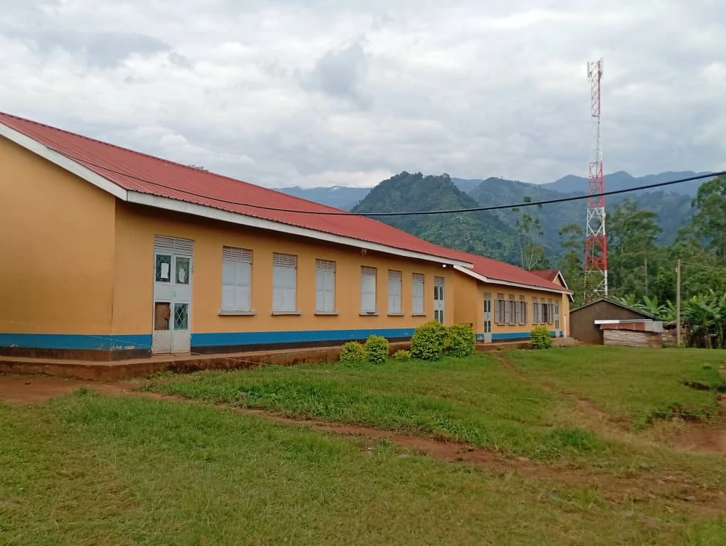 School classroom building with green hills behind it